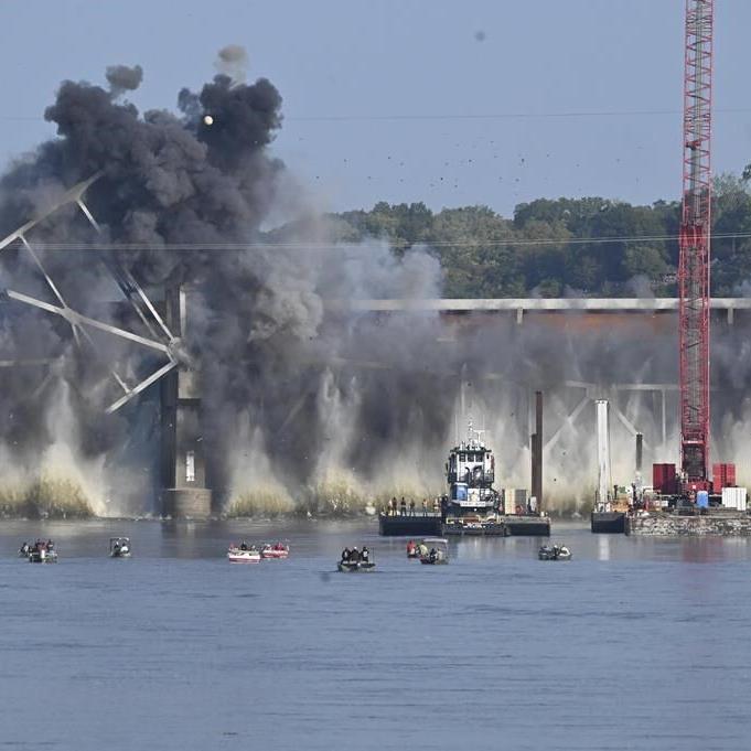 Explosives drop steel trestle Missouri River bridge into the water along I-70 while onlookers watch